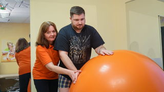 Patient führt Übung mit Gymnastikball durch