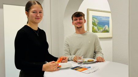 zwei neue Auszubildende an Stehtisch