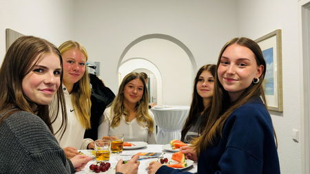 Gruppe neuer Auszubildender an Stehtisch