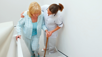 medizinische Fachkraft hilft älterer Dame die Treppe hoch