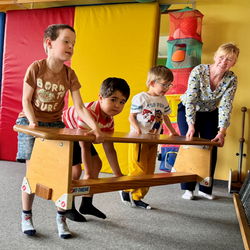 Kinder heben gemeinsam eine Bank hoch