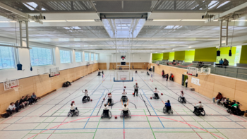einige Kinder im Rollstuhl spielen Ball in der Turnhalle