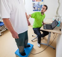 Patient steht auf Gerät zur Überprüfung des Gleichgewichts