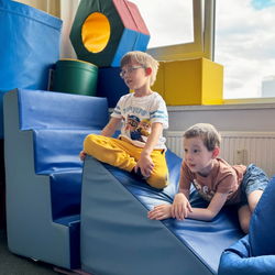 zwei Kinder sitzen auf großem Kletterstein