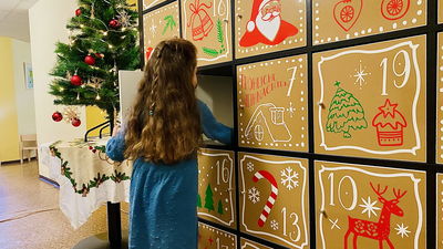 kleines Mädchen holt Geschenk aus dem XXL-Adventskalender