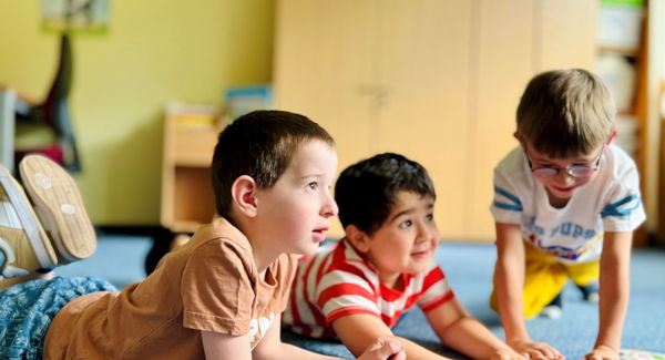 Kinder liegen auf dem Boden und spielen Kartenspiel