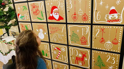 kleines Mädchen sucht die richtige Zahl auf dem XXL-Adventskalender