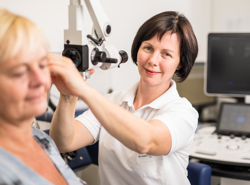 Dr. med. Claudia Ernstberger untersucht das Ohr einer Patientin
