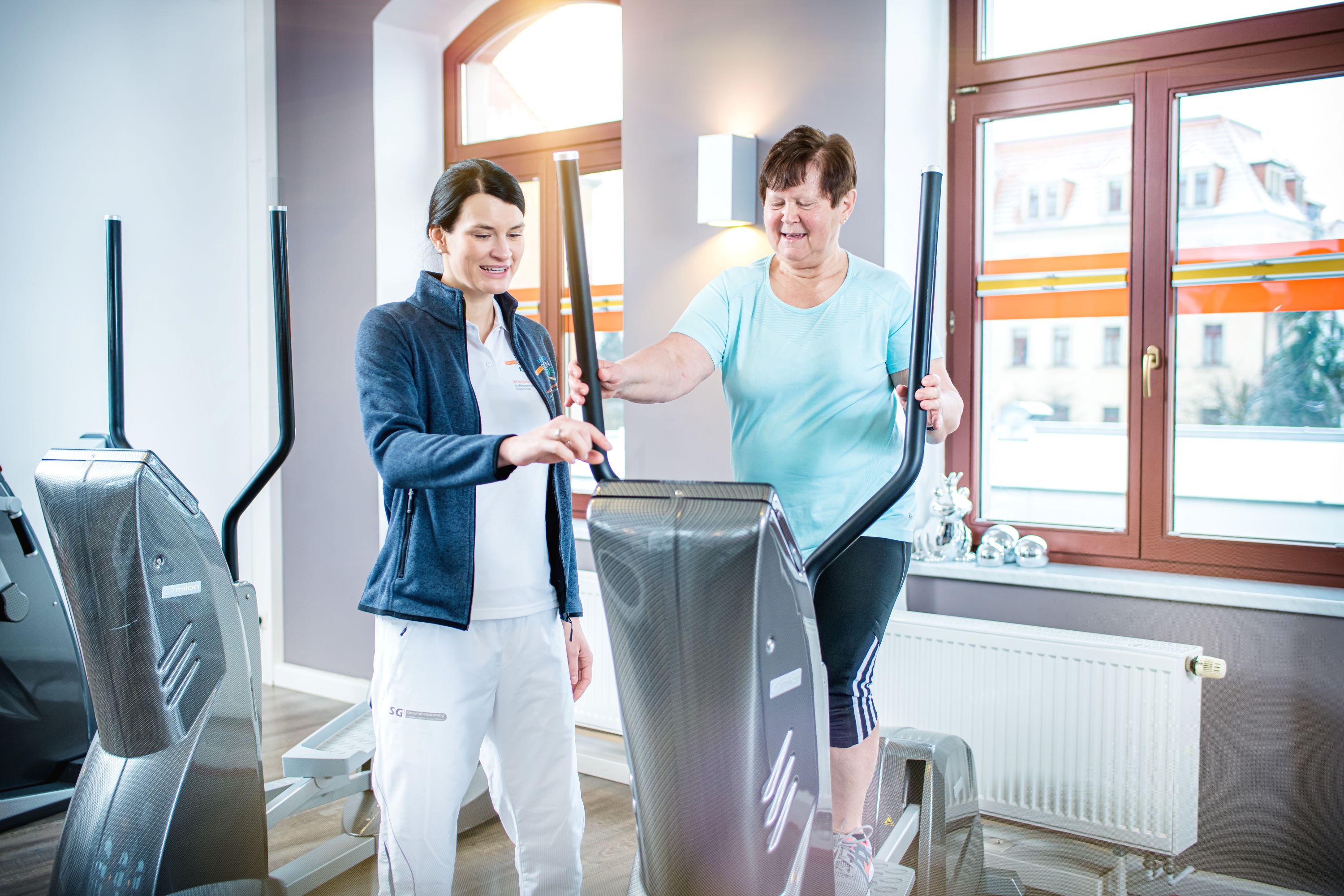 Patientin führt Sportübung auf Gerät aus