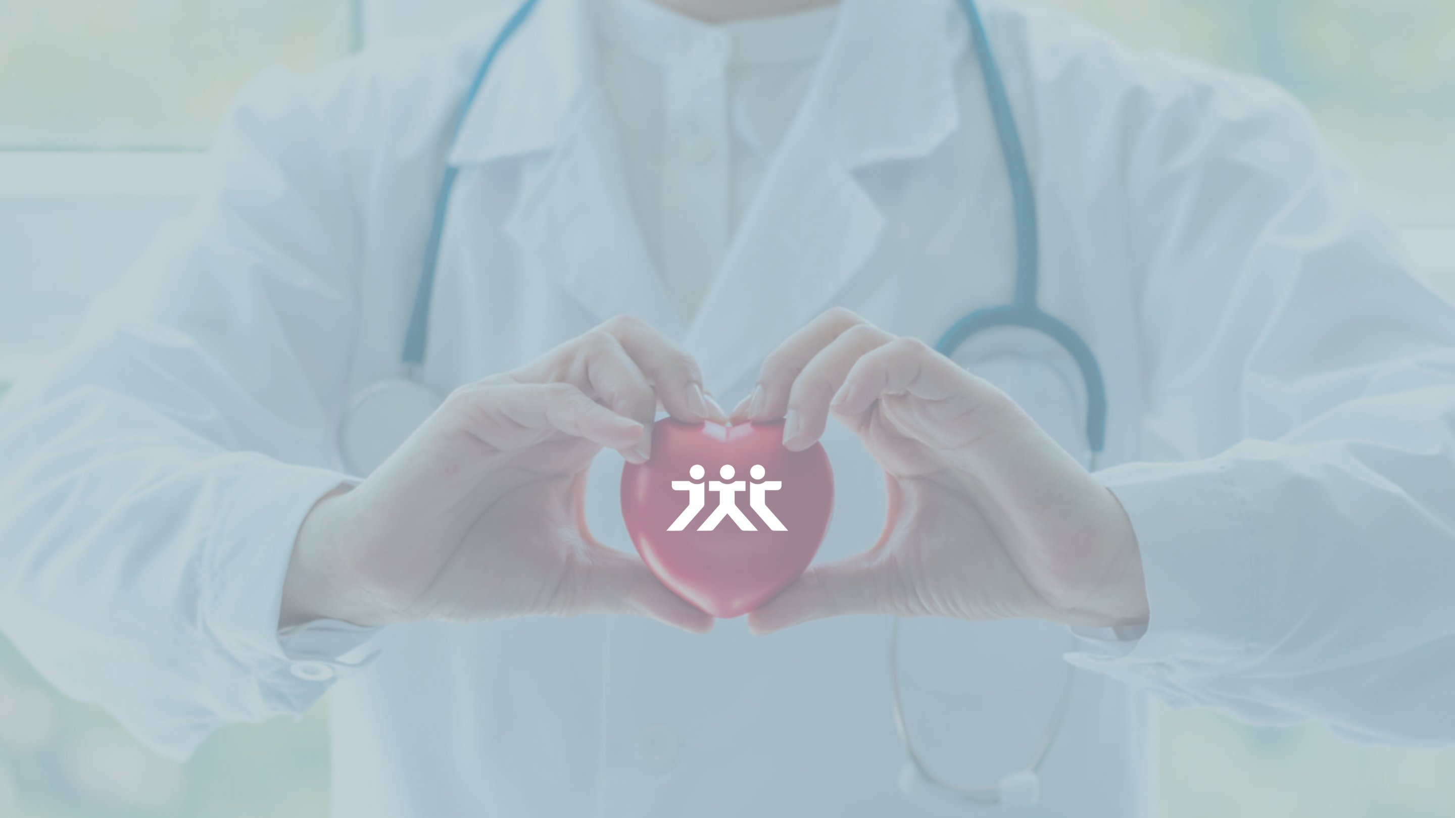 Arzt formt mit seinen Händen ein Herz und hält damit ein rotes Herz